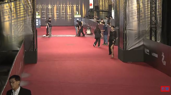 紅毯多處積水，現場工作人員緊急搶救幫忙吸水中。