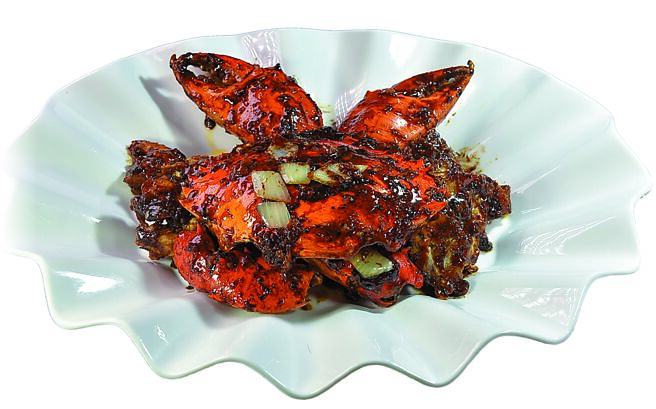 〈晶華軒〉今秋新蟹餚〈黑椒牛油炒蟹〉，是用逾1公斤的斯里蘭卡巨蟹，以鄔海明自製黑椒牛油醬，將牛油、香葉、洋蔥、蒜蓉加入黑胡椒爆香後，與處理過的巨蟹一起拌炒，呈盤上桌鹹香中帶有黑椒香氣。圖／姚舜