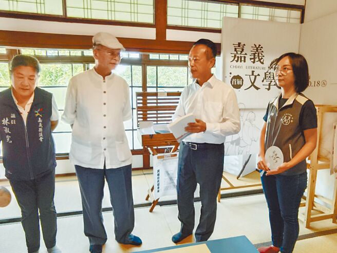 嘉义文学季18日在民雄日式招待所举办，县长翁章梁（右二）参观诗文展品，与诗人渡也（左二）互动。（廖素慧摄）