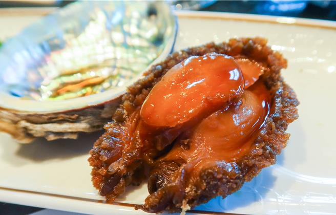 以八角、甘草等十餘種中藥材的潮式醃九孔鮑，Q彈的口感散發出淡淡甘甜味。（粘耿豪攝）