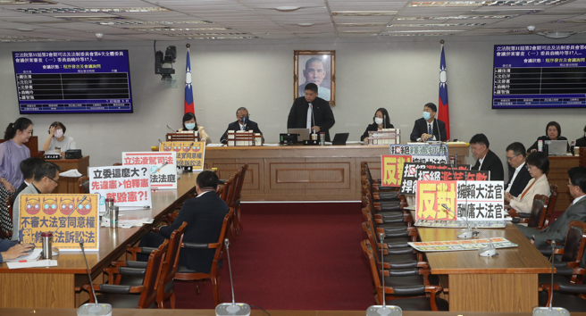 立法院司法及法制委员会21日审查宪法诉讼法部分条文修正草案等案，国民党立委及民进党立委各自摆出标语，表达立场。（刘宗龙摄）