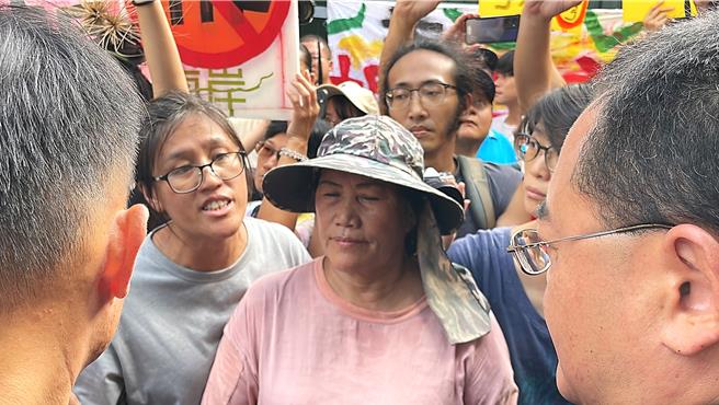 台东县政府建设处建筑管理科长胡炯权（右一）被屋主林金蒂（中）及其女林淑玲（左二）拒于门外。（萧嘉蕙摄）