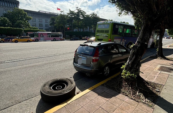 今21日下午2時許，中正區凱達格蘭大道2號前，公車行右前輪軸斷裂，導致右前輪胎脫落，進而撞擊到臨停路旁的小客車左後側。（圖警方提供／簡銘柱翻攝）