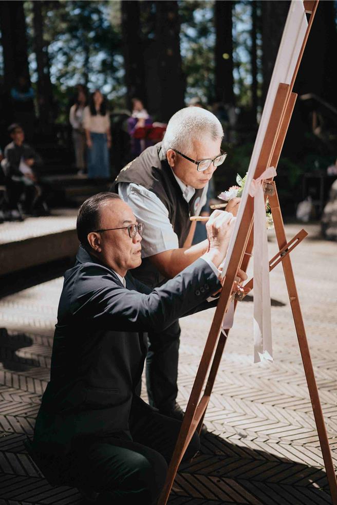 阿里山管理处处长洪维新、阿里山乡长高瑞芳一同签署爱的证书。(阿里山管理处提供／吕妍庭嘉义传真)