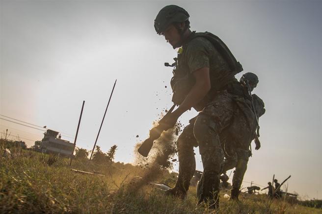  官兵奮力使用十字鎬挖掘駐鋤坑。
（記者林睿奕攝）