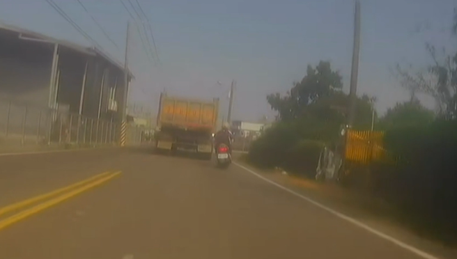 一輛機車硬是往砂石車右側鑽，沒想到當場不慎失控摔車。（翻攝爆料公社）