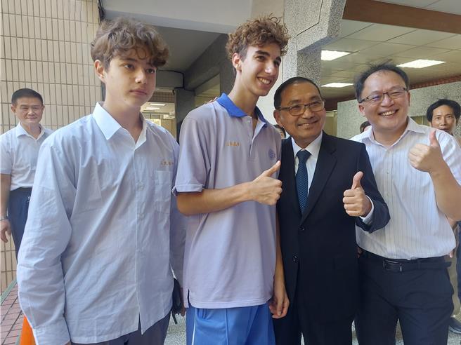 新北市长侯友宜（右二）22日出席新北哈客芦洲馆揭牌启用典礼，与三民高中交换学生合影。（张铠乙摄）