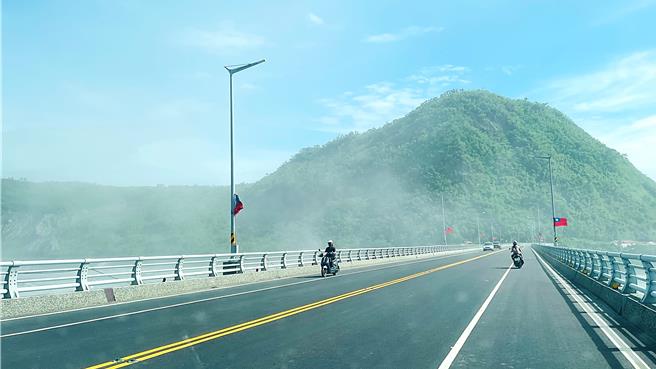 潭美颱風外圍環流及東北季風發威，台東縣卑南溪大片揚塵，機車騎士沙塵中前行。（蕭嘉蕙攝）