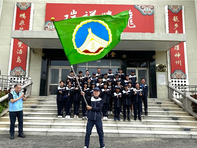 金门县政府今日上午在县府前广场举行2024年全民运动会授旗仪式，由副县长李文良(左前)将县旗授予此次带队的县府参议陈祥麟(前中)，象徵着地区对代表队的全力支持。(图／民眾提供)