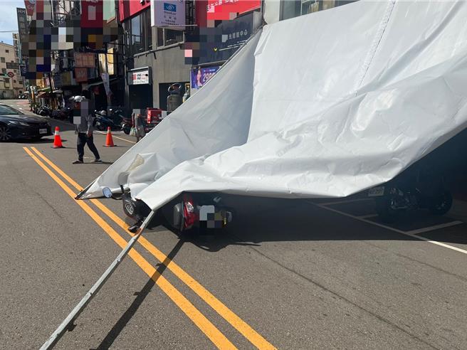 苗栗县23日刮起8至10级强风，苗栗市光復路一间店面发生帆布市招被强风吹落，一名机车女骑士刚好经过被掉落市招击落受伤。（读者提供／谢明俊苗栗传真）