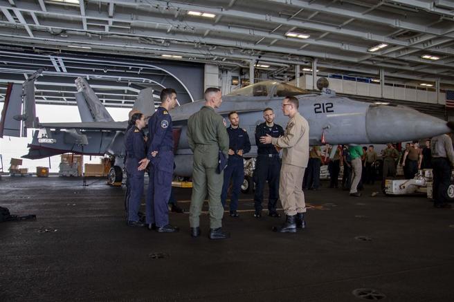  美义航舰18日在中东海域举行双航舰联演，义军官兵（着深蓝色制服）也登上「林肯号」航舰机库甲板，听取美军介绍作业流程。（取自DVIDS网站）