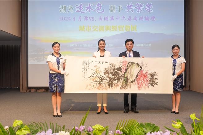 南投縣長許淑華贈送杭州市2幅台灣本土寫實派水墨大師李轂摩的作品，杭州市副市長胥偉華代為收下禮物。（楊靜茹攝）