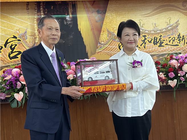 萬和宮董事長蕭清杰將象徵復康巴士的模型交給盧秀燕。（林欣儀攝）