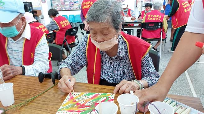 华山基金会竹南爱心天使站，25日上午在圣福社区活动中心举办「建站十四周年感恩茶会」带领长辈体验「手指云彩绘画」（华山基金会提供／谢明俊苗栗传真）