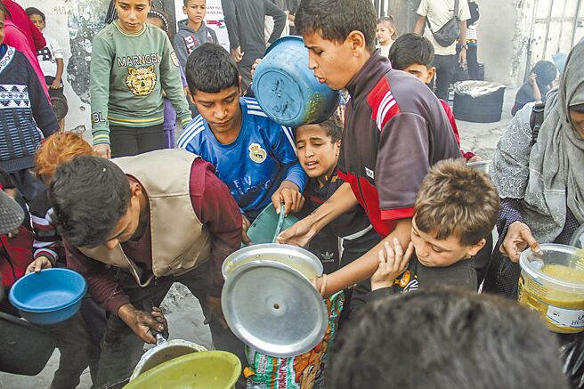 中國常駐聯合國代表團美東時間23日指出，當前迦薩衝突延宕，中東局勢惡化，國際社會必須共同努力，避免衝突動盪蔓延至敘利亞。圖為迦薩人們領取救濟食品。（新華社）