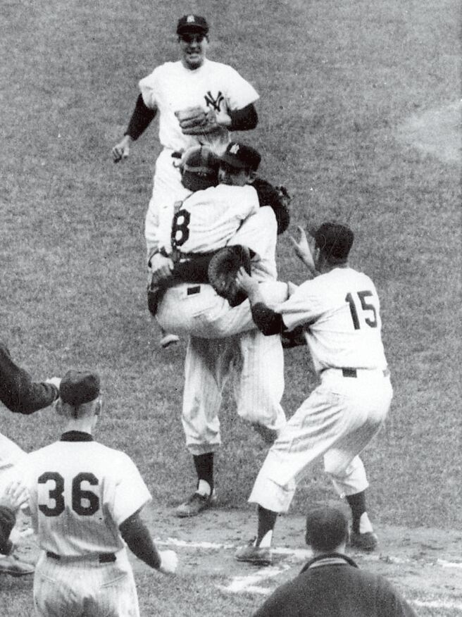 拉森在1956年对道奇投出世界大赛歷来唯一的「完全比赛」后，拥抱跳到他身上的名人堂铁捕尤基贝拉（8号）。（美联社）
