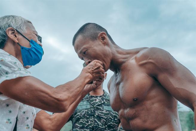  亲友亲喂象徵「苦尽甘来」糖果，并热情给予拥抱，肯定学员坚忍不拔的钢铁意志。（记者陈怡璇摄）