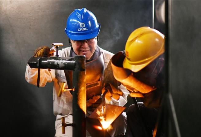 工匠引领！陆这样壮大产业工人主力军。图为今年2月4日中车齐齐哈尔车辆有限公司货车分厂电焊高级技师、高级工程师王海（左）指导徒弟焊接试件。（新华社）