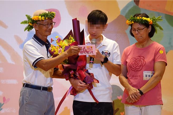 有中度障礙的源源（中）念出對寄養爸媽李達仁（左）、李育庭（右）的感謝。（羅琦文攝）