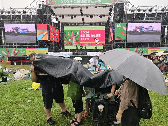 全民運動會昨晚在雨中開幕，觀眾在雨中長達2、3個小時。（羅琦文攝）