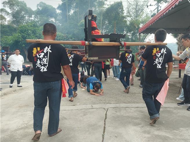 民政局长林耀长带头钻轿脚，让顶福巖诸祖辇轿帮信眾消灾除厄。（张铠乙摄）