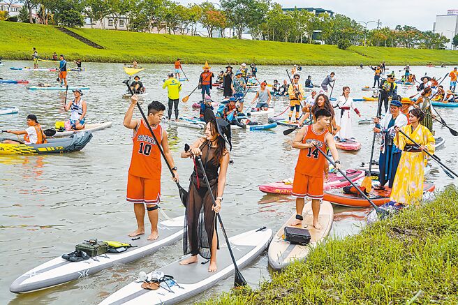 宜蘭縣冬山河將開放水域遊憩活動，台灣開放水域聯盟號召SUP立槳運動等玩家，26日以嘉年華形式變裝下水。（李忠一攝）