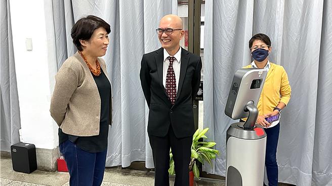台东大学校长郑宪宗（中）向台东县长饶庆铃（左）展示互动式机器人。（萧嘉蕙摄）
