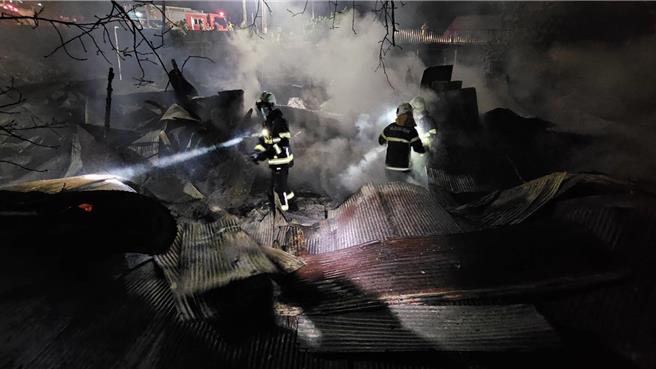 遠水救不了近火，紅香部落2民宅付之一炬，消防人員撲滅火勢後，拿手電筒在燒毀的斷垣殘壁上來回搜索，確定沒人傷亡。（林庭秝提供／楊靜茹南投傳真）