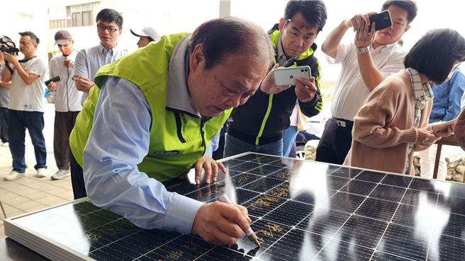 澎湖南寮社区成立首座公民电厂，30日举行开工仪式，澎县长陈光復在太阳能板上签名纪念。（许逸民摄）