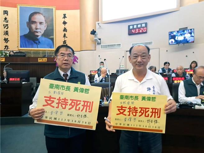 国民党台南市议员许至椿30日拿「支持死刑」的手板请台南市长黄伟哲签名，但黄伟哲自行更改为「反对废除死刑」后签名。（洪荣志摄）