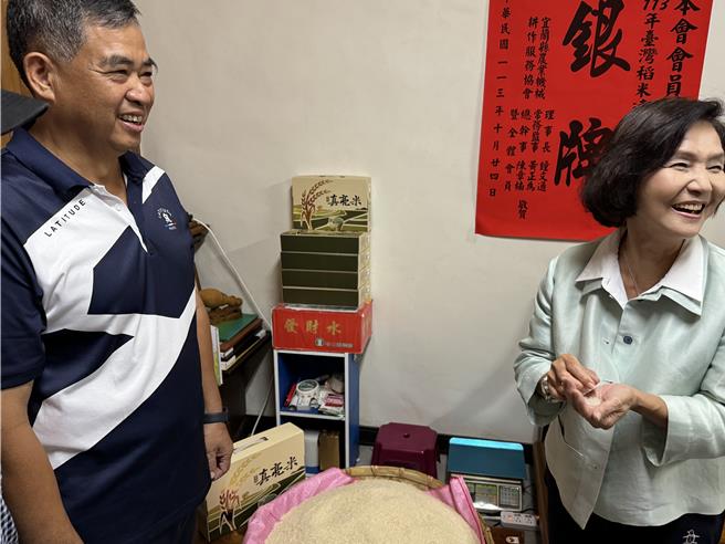 宜兰县长林姿妙（右）捧一把米闻着淡淡的芋头香。（吴佩蓉摄）