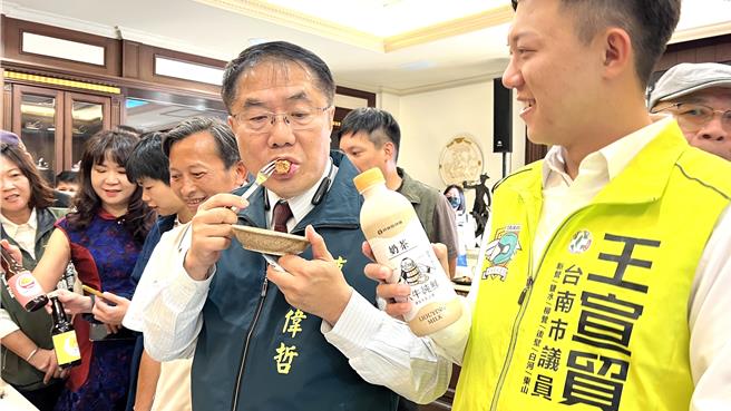 台南市长黄伟哲（右二）今（30）日下午出席大新营嘉年华的行前宣传活动时，看到满桌子的美食佳肴，忍不住每个都多吃几口。（张毓翎摄）