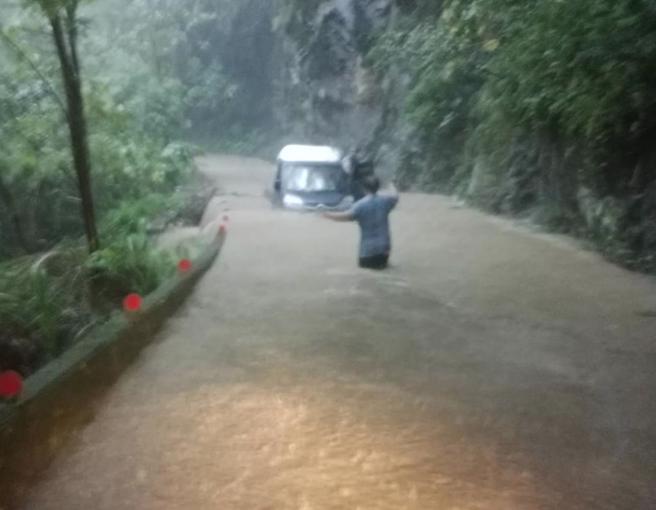 尖石養老路段4K處疑似因土石崩落堵住排水口，加上雨勢過大，道路積淹水讓硬闖的小貨車直接卡在水深處。（民眾提供／邱立雅竹縣傳真）