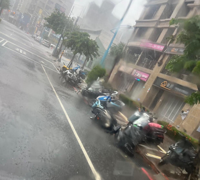 新北市蘆洲區三民路上，停放在商店前面的一排機車被強風吹倒。（圖 / 翻攝自臉書粉專「我是蘆洲人」）