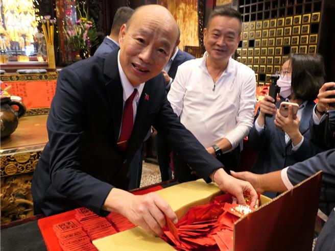 雲林縣北港武德宮財神廟31日舉辦「純金錢母投置母庫」儀式，將市價150萬元的300份金幣小紅包，混入20萬份2元硬幣小紅包內，立法院長韓國瑜（左）在颱風天冒著風雨前來，見證百萬金幣大放送，祈求百姓平安發財。（張朝欣攝）