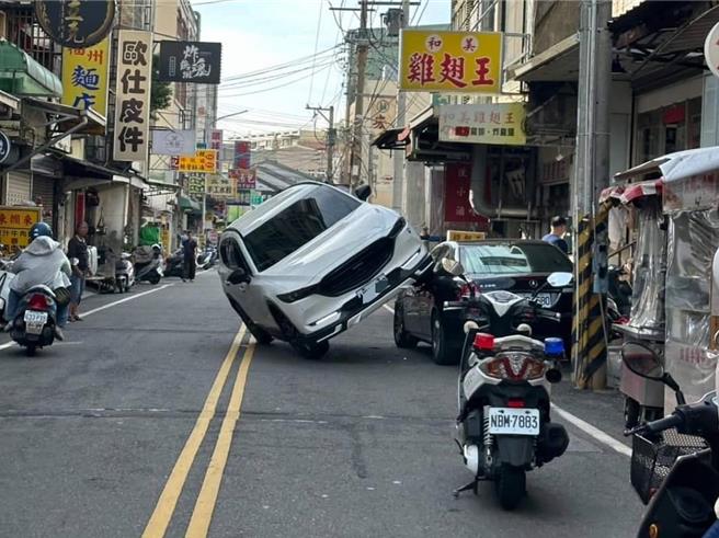 楊男昨天駕車擦撞路旁車輛，楊男的車子側掛在被撞車輛上。（民眾提供／孫英哲彰化傳真）