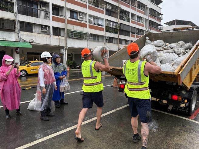 澳洲消防隊來台參訪交流，遭遇強颱康芮來襲，10位澳洲猛男消防員昨日特別加入側溝清疏防災作業，體驗高雄清潔隊員們的辛勞。（高市府環保局提供／洪浩軒高雄傳真）