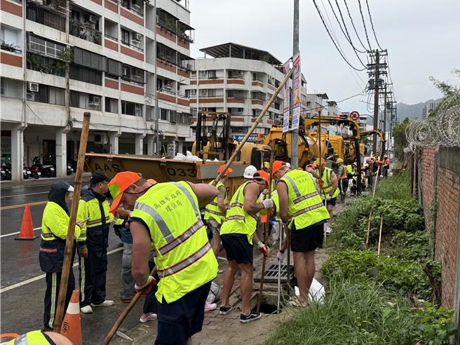澳洲消防隊來台參訪交流，遭遇強颱康芮來襲，10位澳洲猛男消防員昨日特別加入側溝清疏防災作業，體驗高雄清潔隊員們的辛勞。（高市府環保局提供／洪浩軒高雄傳真）