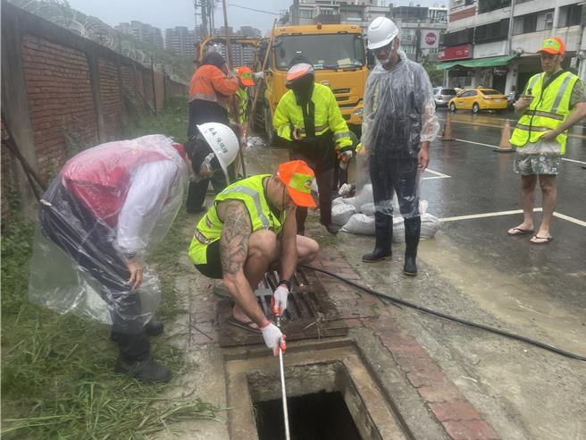 澳洲消防隊來台參訪交流，遭遇強颱康芮來襲，10位澳洲猛男消防員昨日特別加入側溝清疏防災作業，體驗高雄清潔隊員們的辛勞。（高市府環保局提供／洪浩軒高雄傳真）