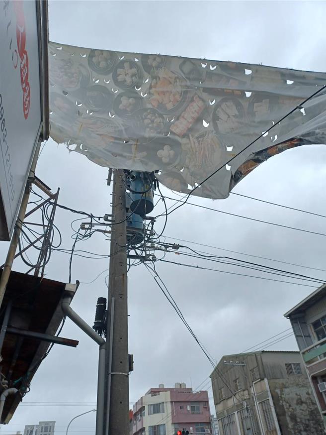 广告帆布被强风吹损影响台电线路，造成停电，台电派员移除。(台电台南区处提供／曹婷婷台南传真)