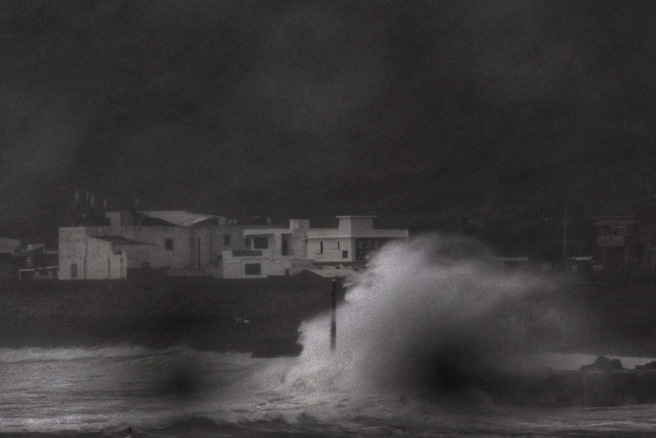 康芮18:40出海，但东部雨势仍非常猛烈。图为东北角海岸边的浪花被颱风吹起，比一旁的楼房还高。（邓博仁摄）