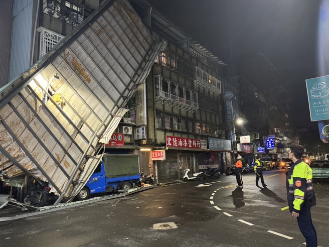 5樓頂加蓋的鐵皮違建，被強風吹落懸掛在公寓牆面，現場相當恐怖，因為不知道何時會掉落，警方立即封鎖現場。（警方提供）