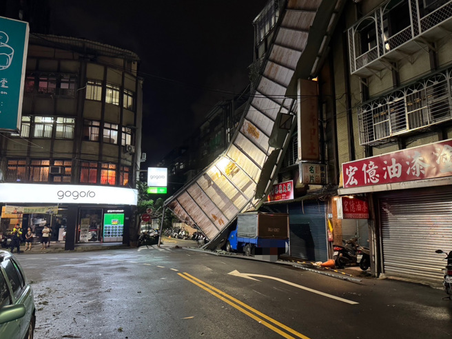 5樓頂加蓋的鐵皮違建，被強風吹落懸掛在公寓牆面，現場相當恐怖，因為不知道何時會掉落，警方立即封鎖現場。（警方提供）