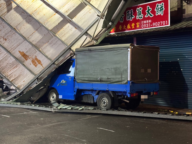 5樓頂加蓋的鐵皮違建，被強風吹落懸掛在公寓牆面，現場相當恐怖，因為不知道何時會掉落，警方立即封鎖現場。（警方提供）