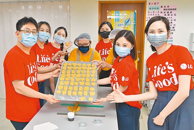 台灣LG電子董事長鄭淵寬（左一）率領同仁前往「喜憨兒基金會」民生工坊一同製作餅乾。（LG提供）