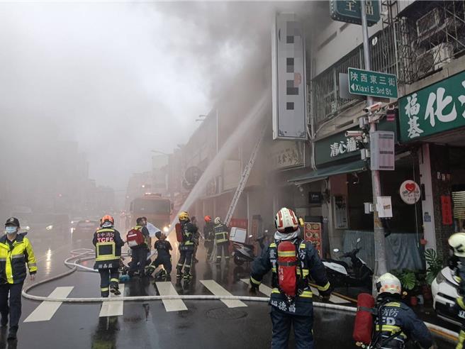 台中市北区汉口路1日清晨近6时传出民宅火警，现场冒出浓烟直窜天际，并在2、3楼各有1人受困，目前救出1名年约55岁女子送医坑，持续抢救中。（消防局提供／潘虹恩台中传真）