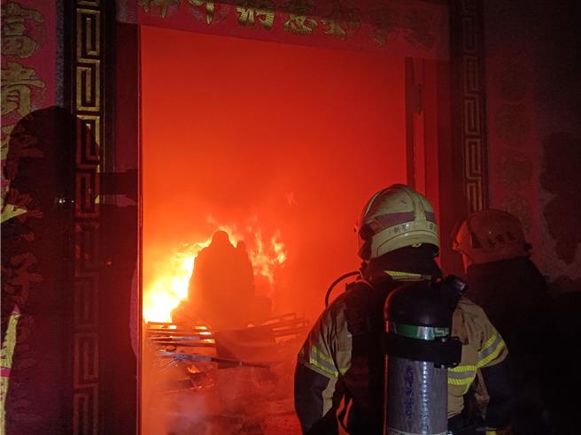 台南市新營區復興路上的妙法禪寺，今（2）日凌晨1點1樓突然竄出火煙，消防人員抵達現場後拉水線灌救。（讀者提供／張毓翎台南傳真）