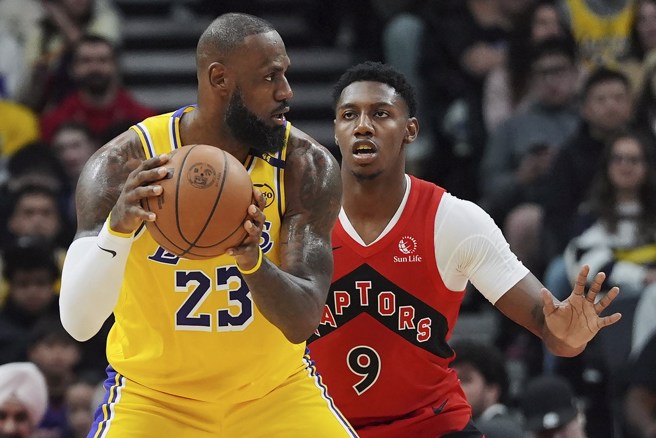 詹姆斯(左)持球面对巴雷特防守。(美联社)