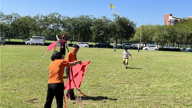 眾人在前方大草皮放风筝，现场因为风太小，最后几乎变成「遛风筝」，不过大小朋友还是很开心，到处跑来跑去。（张毓翎摄）