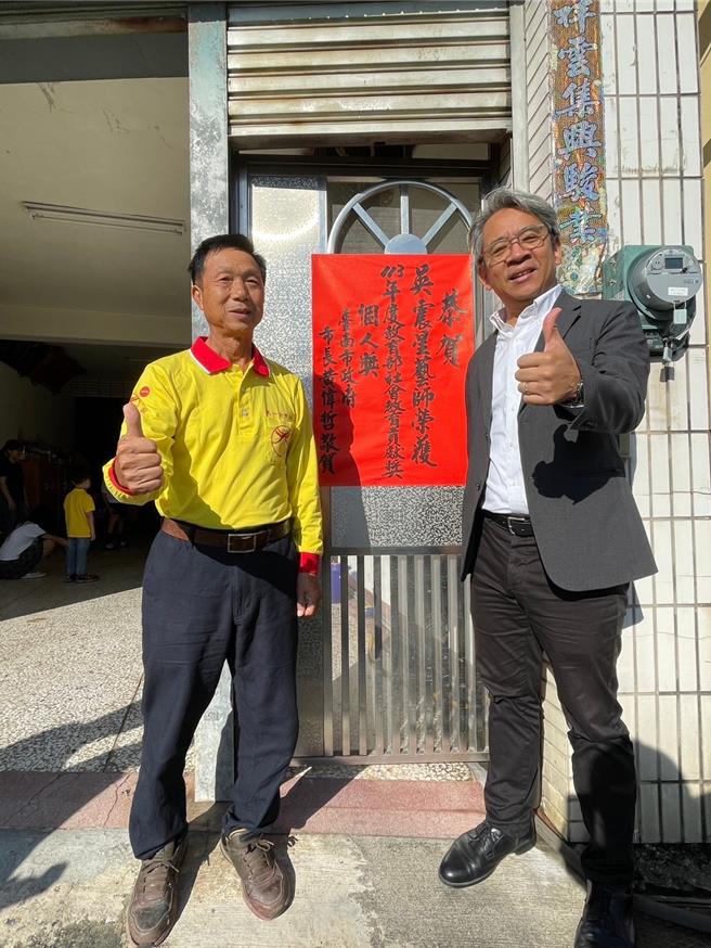 文化局长谢仕渊(右)前往吴震星艺师家张贴红榜。(文化局提供／曹婷婷台南传真)